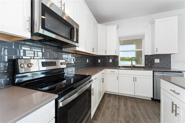 an empty room with wooden floor and windows with lake view