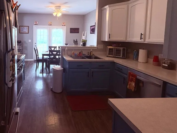 a kitchen with stainless steel appliances granite countertop a stove a sink dishwasher and cabinets with wooden floor