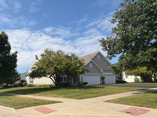 a view of a house with a yard and large trees