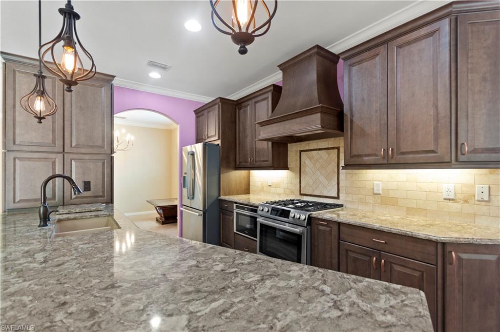 20451 Rookery Drive Estero, FL 33928 - Photo 3 of 44 a kitchen with granite countertop a stove a sink and a refrigerator