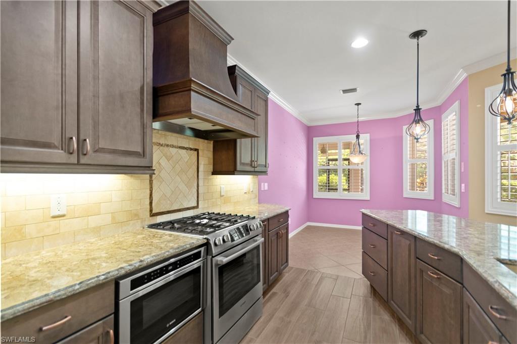 20451 Rookery Drive Estero, FL 33928 - Photo 6 of 44 a kitchen with stainless steel appliances granite countertop a stove a sink and a microwave