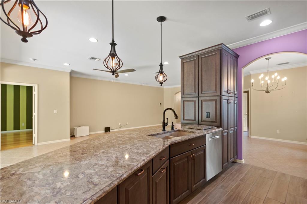 20451 Rookery Drive Estero, FL 33928 - Photo 10 of 44 a kitchen with stainless steel appliances granite countertop a sink refrigerator and cabinets