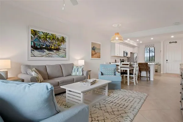 a living room with furniture and a dining table with kitchen view