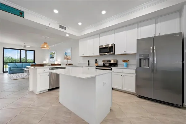 a kitchen with white cabinets and refrigerator