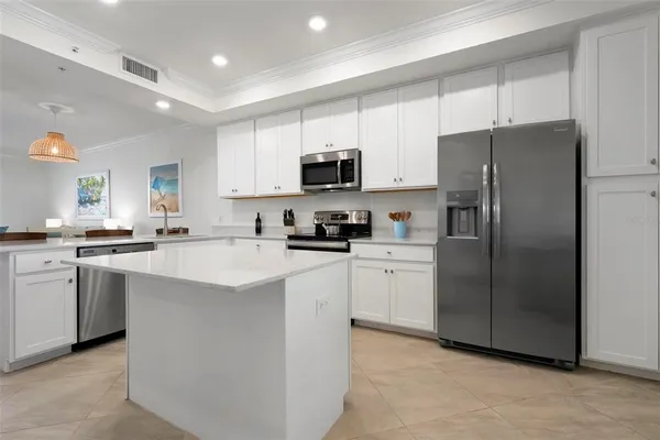 a kitchen with a refrigerator a sink and a stove top oven