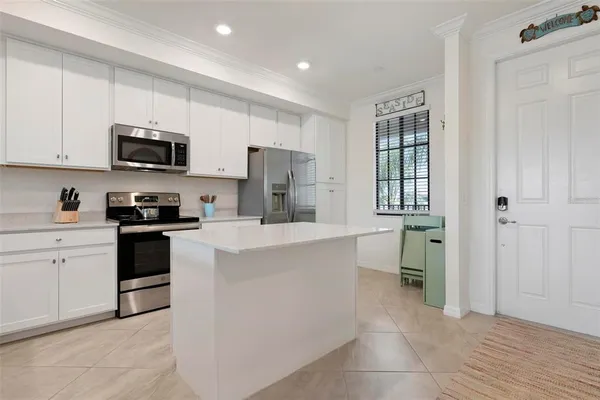 a kitchen with stainless steel appliances a refrigerator sink and microwave