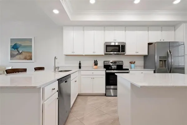 a kitchen with stainless steel appliances a refrigerator sink and white cabinets