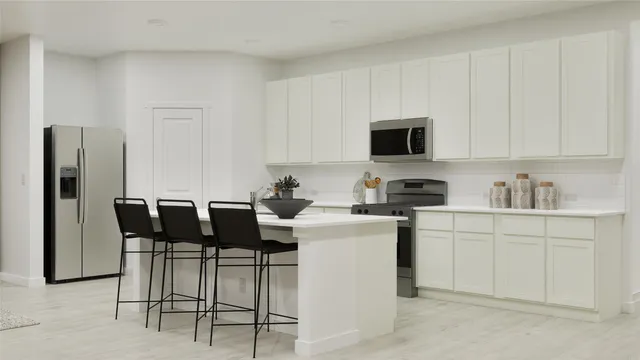 a kitchen with stainless steel appliances kitchen island granite countertop a table and chairs