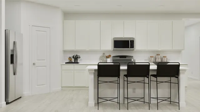 a kitchen with a stove and white cabinets