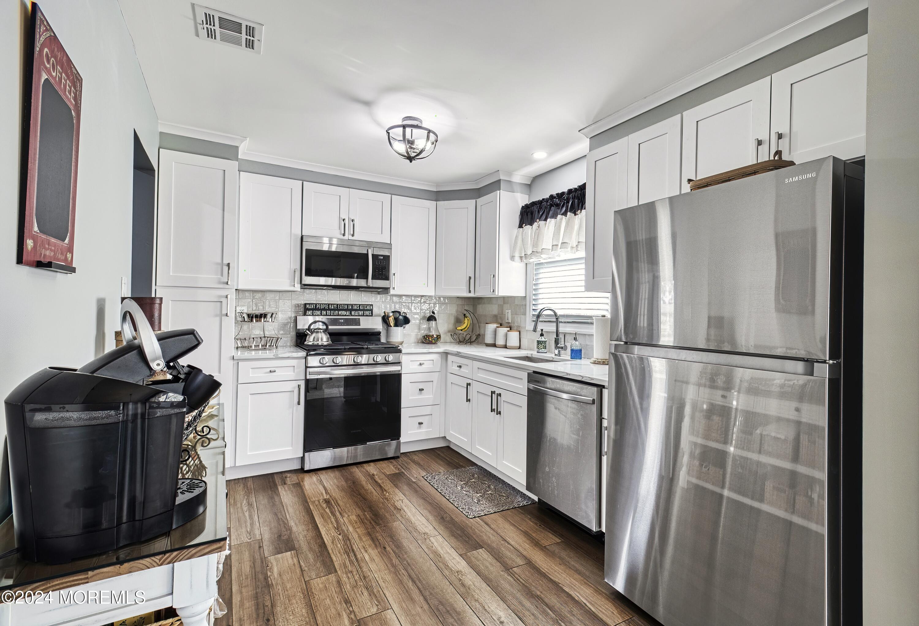6 Masters Road Brick, NJ 08724 - Photo 12 of 38 a kitchen with granite countertop a refrigerator stove and microwave