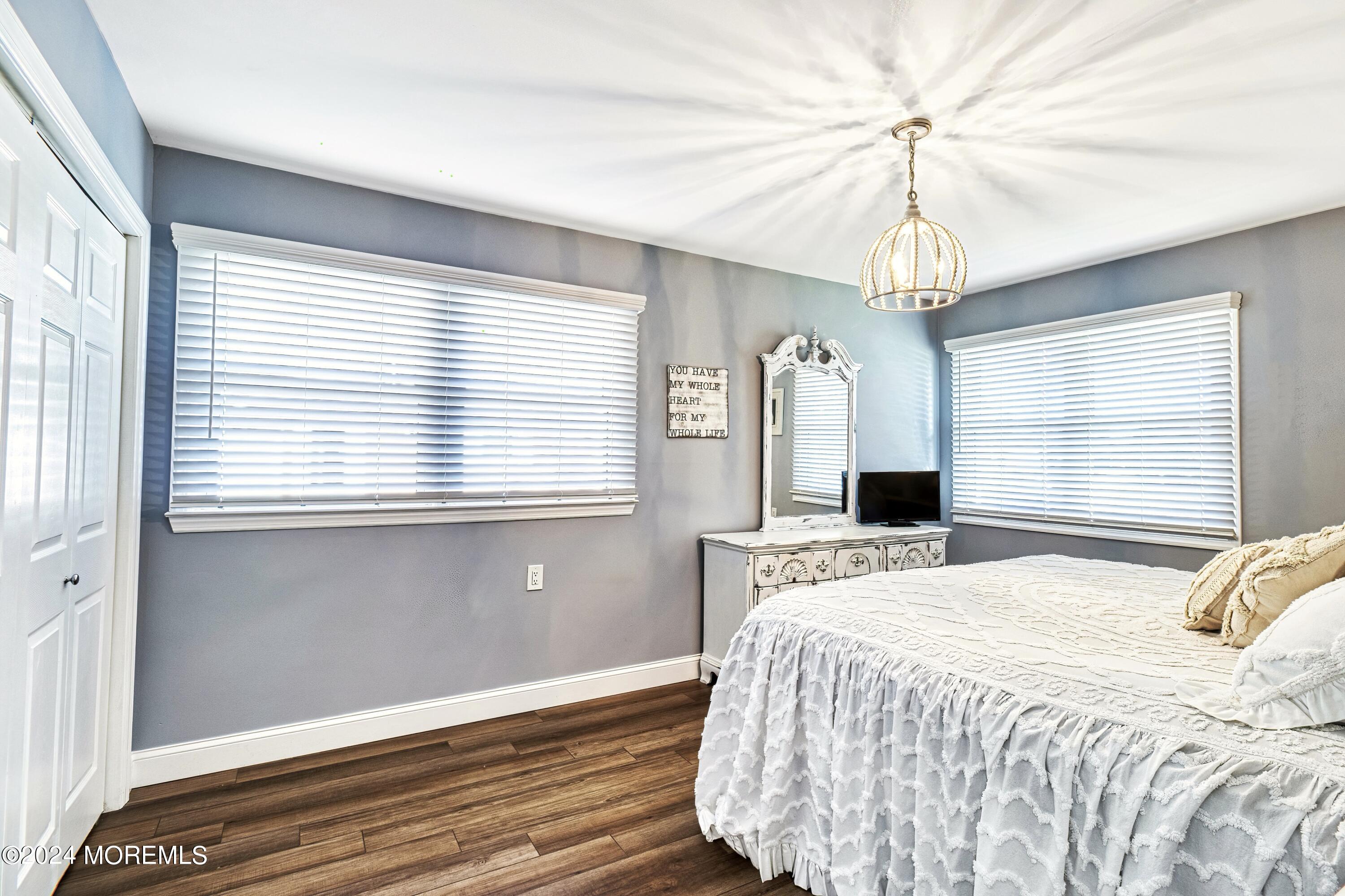 6 Masters Road Brick, NJ 08724 - Photo 18 of 38 a bedroom with a large bed and a chandelier
