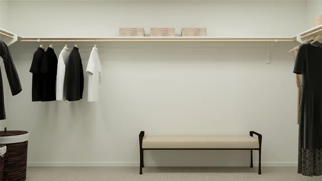 a view of walk in closet with clothes and shoes