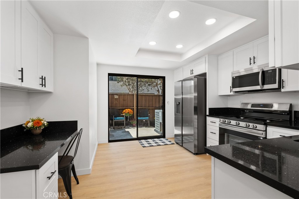 a kitchen with stainless steel appliances kitchen island granite countertop a stove refrigerator and microwave