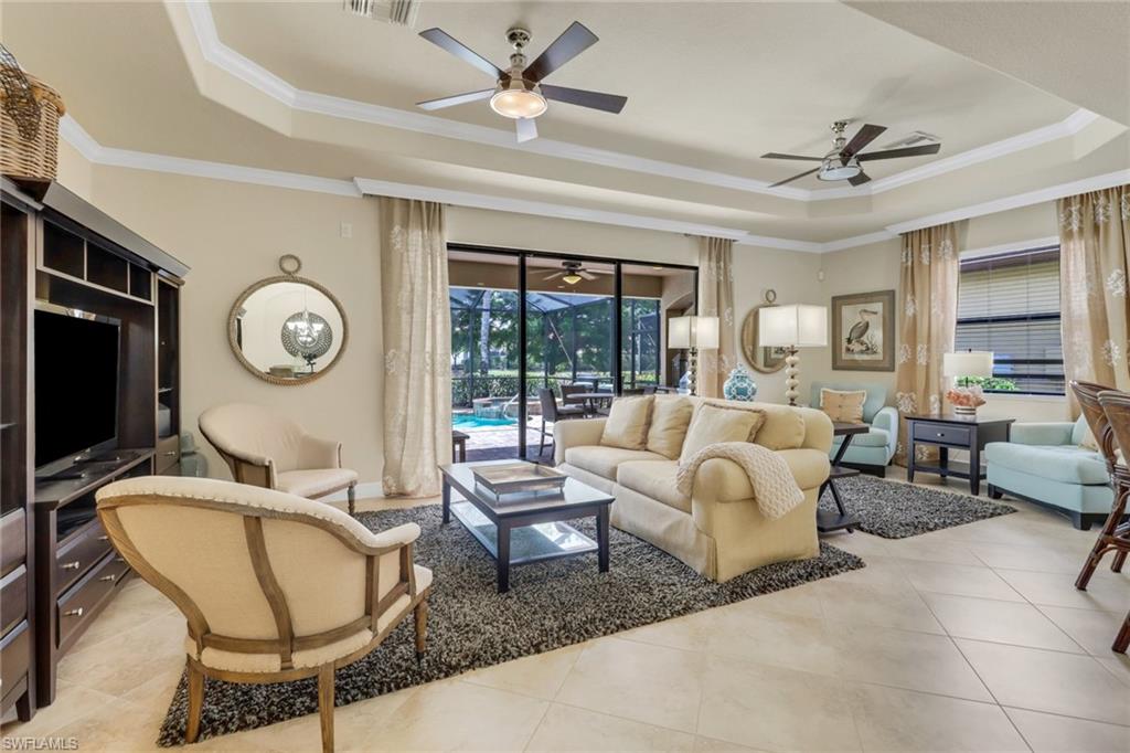 9434 Piacere Way Naples, FL 34113 - Photo 10 of 32 Living room featuring a tray ceiling, a ceiling fan, light tile patterned floors, and ornamental molding