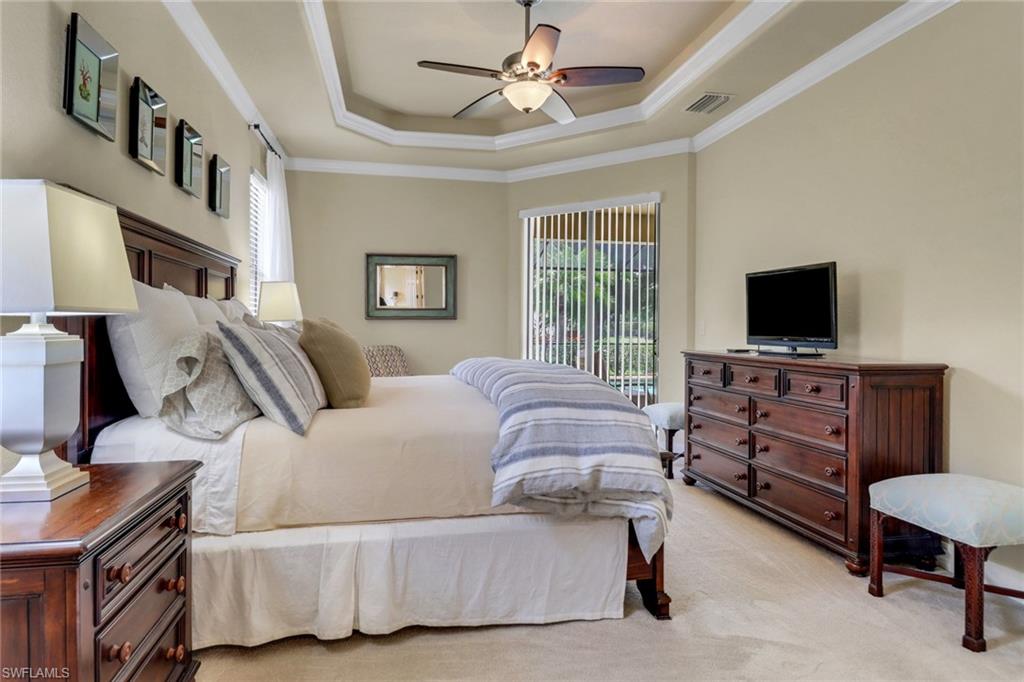 9434 Piacere Way Naples, FL 34113 - Photo 16 of 32 Bedroom with ornamental molding, a tray ceiling, light carpet, access to exterior, and ceiling fan