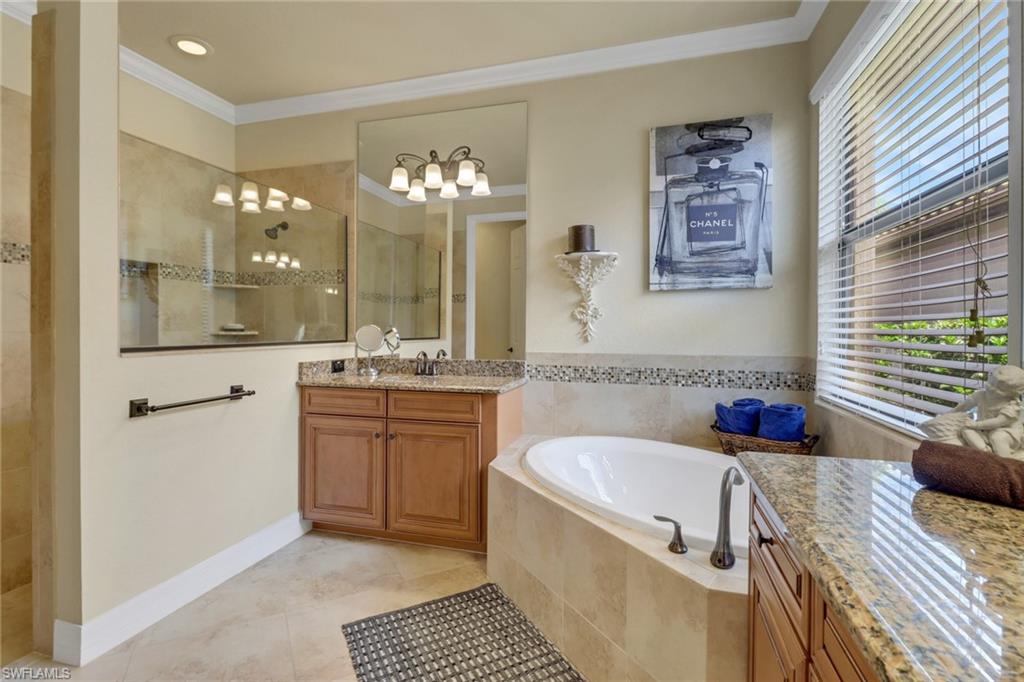 9434 Piacere Way Naples, FL 34113 - Photo 17 of 32 Full bath featuring vanity, ornamental molding, walk in shower, a garden tub, and tile patterned floors