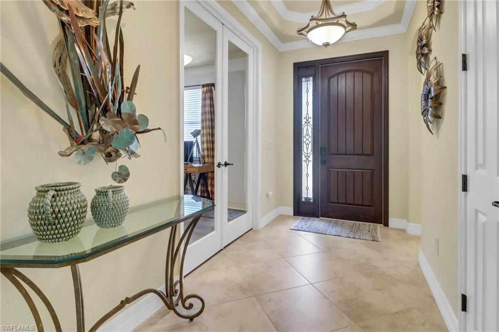 9434 Piacere Way Naples, FL 34113 - Photo 5 of 32 Foyer with ornamental molding, french doors, and light tile patterned floors