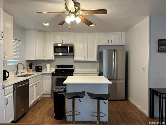 a kitchen with a refrigerator and a stove top oven