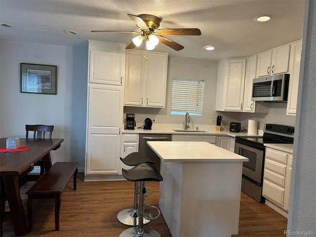 a large kitchen with cabinets appliances and a dining table