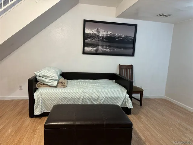 a bedroom with a bed and wooden floor