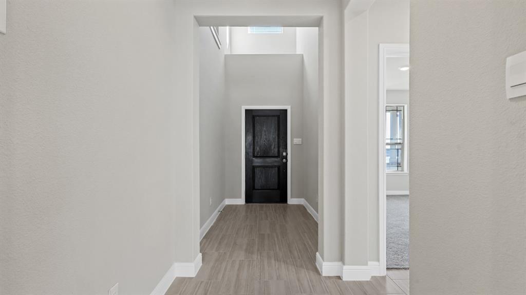 11305 Treehouse Trail Justin, TX 76247 - Photo 17 of 39 a view of a hallway with wooden floor and closet