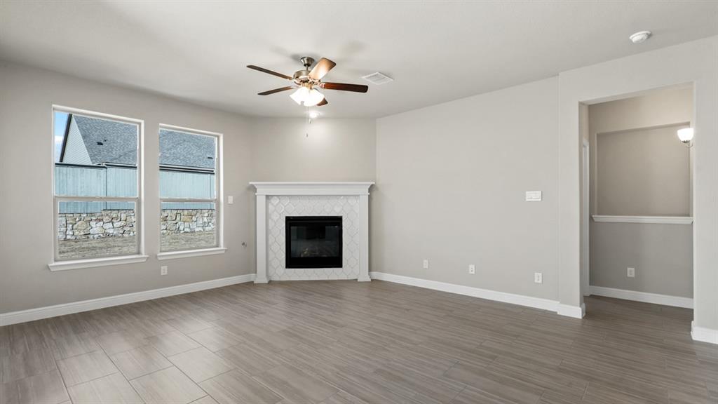 11305 Treehouse Trail Justin, TX 76247 - Photo 7 of 39 a view of an empty room with a window and wooden floor