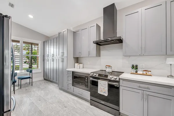 a kitchen with stainless steel appliances a stove a refrigerator and cabinets