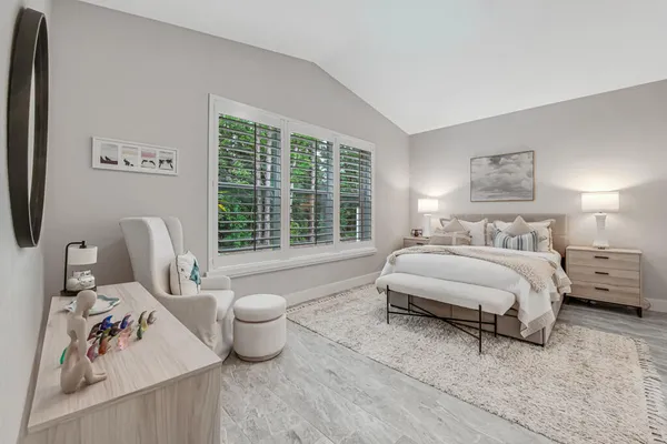 a spacious bedroom with a bed and wooden floor