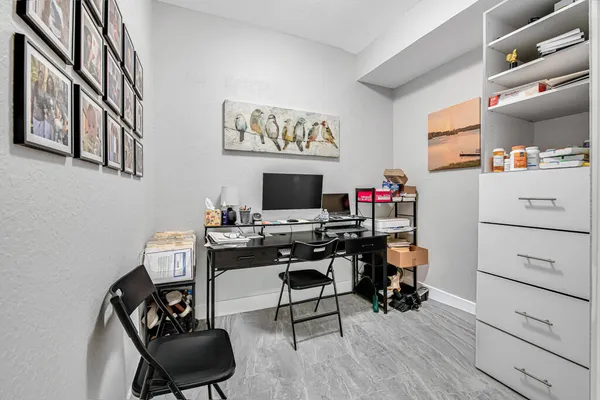 a view of a workspace with furniture and a window
