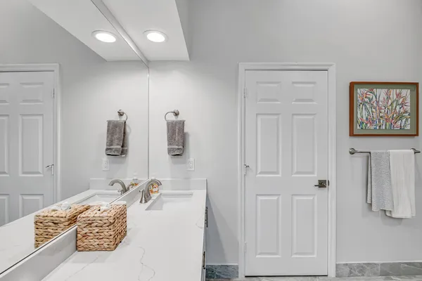a bathroom with a tub sink and mirror