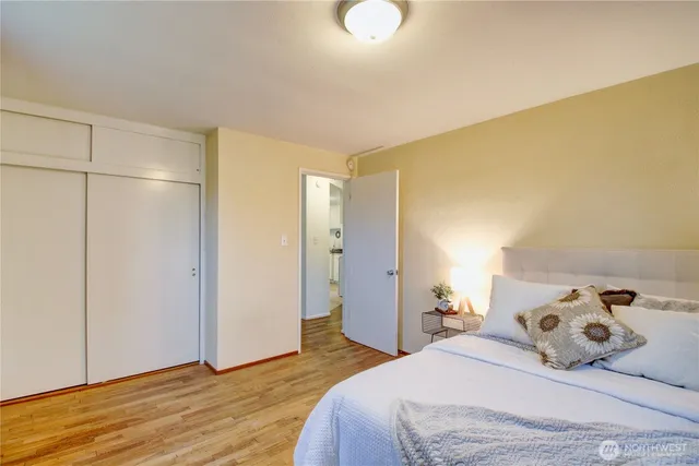 a bedroom with a bed and wooden floor