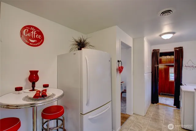 a kitchen with a refrigerator and a table