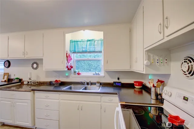 a kitchen with granite countertop a sink stove and cabinets
