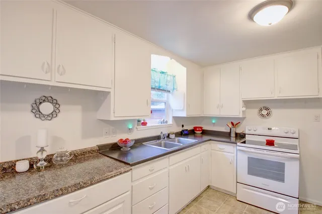 a kitchen with granite countertop a sink cabinets and window