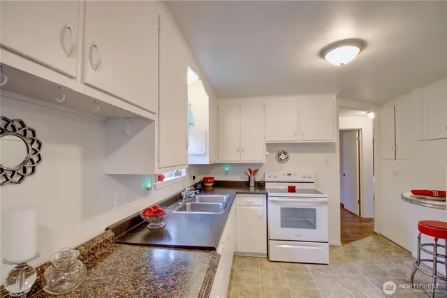 a kitchen with white cabinets and appliances