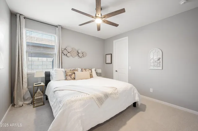 a bedroom with a large bed and a ceiling fan