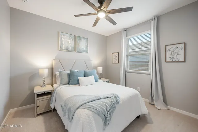 a bedroom with a bed and a chandelier fan