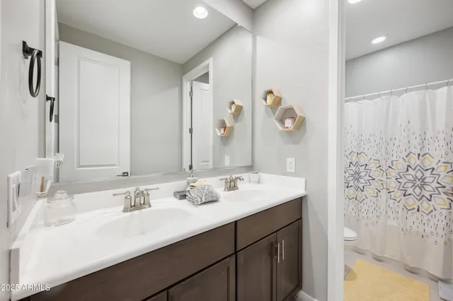 a view of a patio with couches table and chairs under an umbrella with a fire pit and large trees