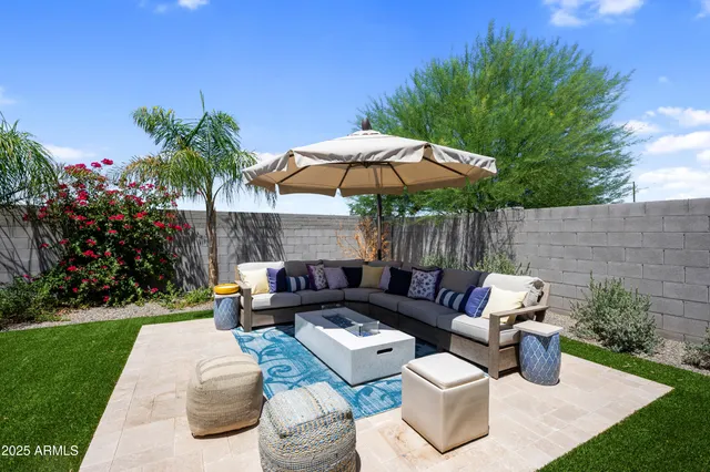 a view of a patio with a table and chairs under an umbrella