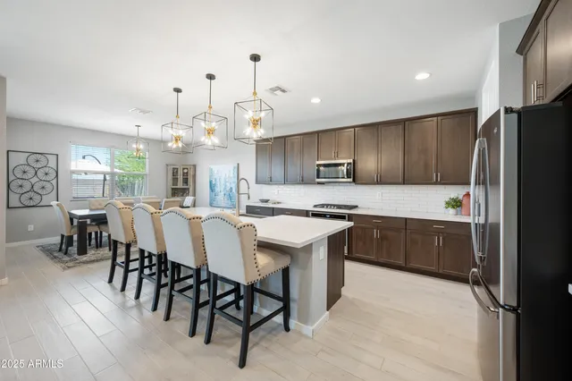 a living room with furniture kitchen view and a large window