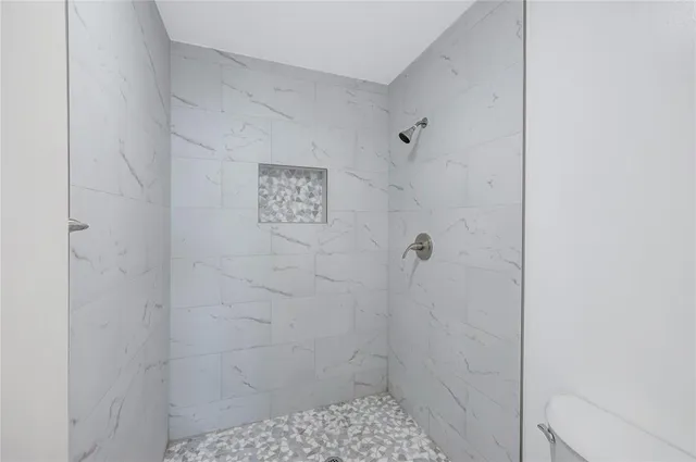 a bedroom with a bed and a lamp on dresser