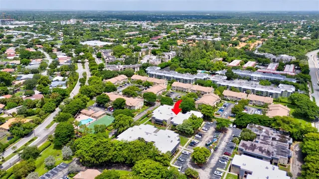 an aerial view of residential houses with outdoor space and trees