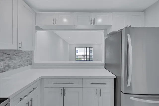 a kitchen with white cabinets sink and dishwasher
