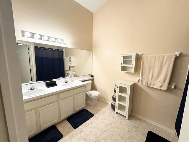 a bathroom with a double vanity sink toilet and mirror
