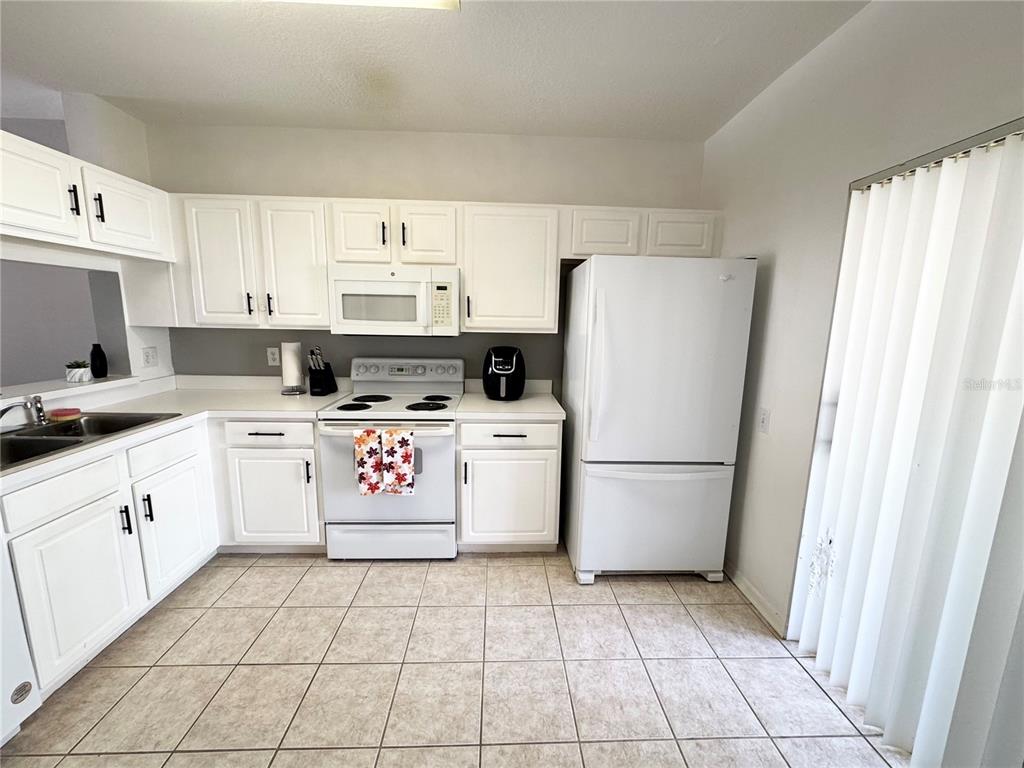 2246 Lake Woodberry Circle Brandon, FL 33510 - Photo 10 of 21 a kitchen with a refrigerator a stove top oven and cabinets