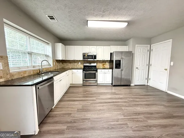 a kitchen with stainless steel appliances granite countertop a sink and cabinets