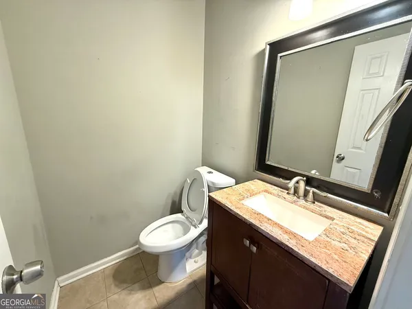 a bathroom with a granite countertop sink toilet and mirror