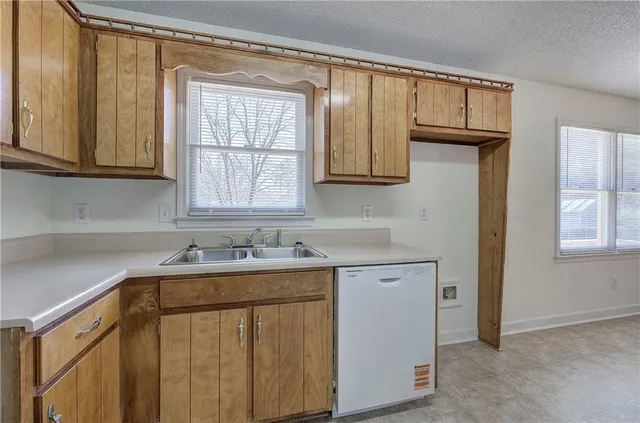 a kitchen with a sink cabinets and a window