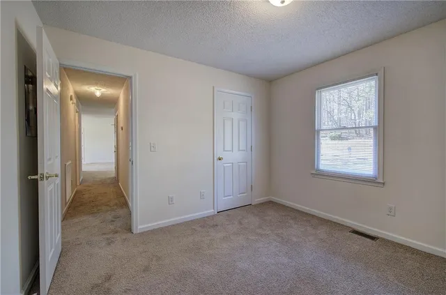 an empty room with windows and closet