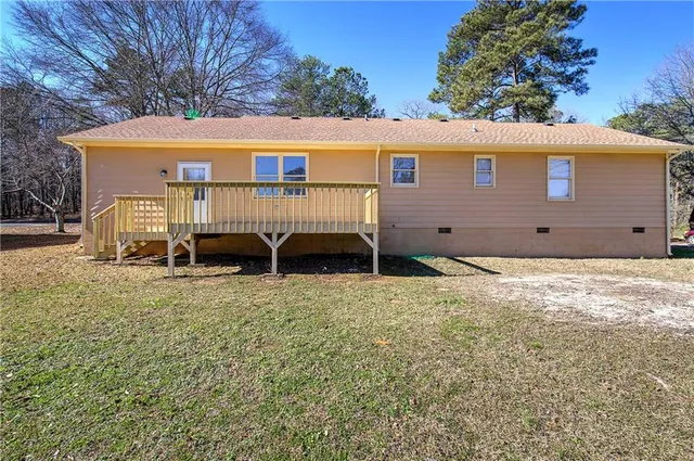 a view of a house with a yard and deck